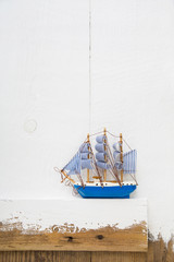 Blaues Segelschiff Holz Dekoration auf Hintergrund weiß für Konzepte im Hochformat
