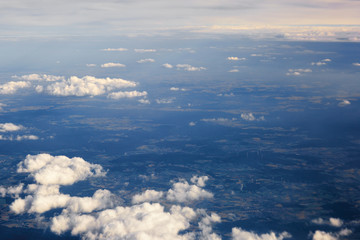 Fluffy clouds over the earth, the landscape. The scenic sky during sunset, the view from the air.