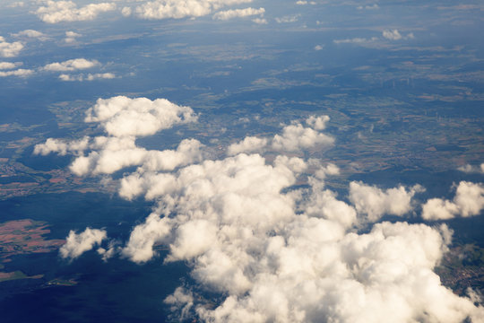 Fluffy clouds over the earth, the landscape. The scenic sky during sunset, the view from the air.
