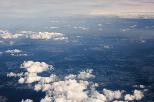 Fluffy clouds over the earth, the landscape. The scenic sky during sunset, the view from the air.
