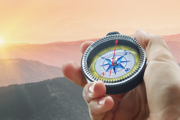 compass and hand in mountains
