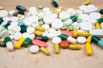 Composition with colorful pills and wooden background