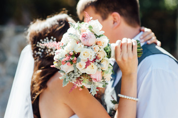 bride and groom together holding wedding bouquet