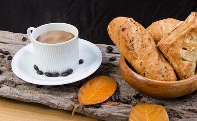 Coffee cup and bread on a wooden table. Breakfast