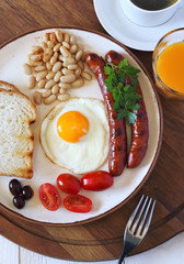 English breakfast with sausage, fried egg and  baked beans
