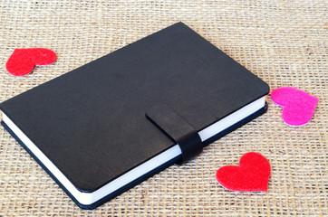 The paper hearts and notebook on the sackcloth