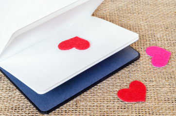 The paper hearts and notebook on the sackcloth