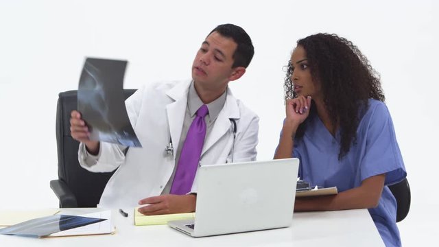 Doctor discussing x-rays with nurse and taking notes