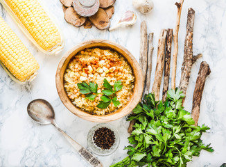 red lentil soup with corn, paprika and herbs in wooden plate