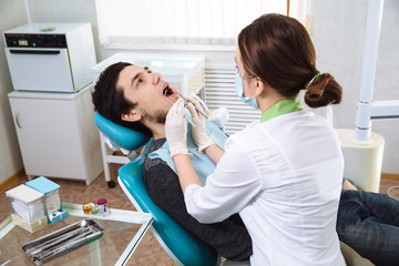 Fototapeta premium Female dentist with male patient at dental office. Concept of healthy