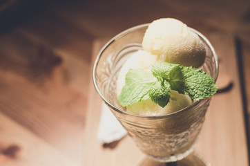 Mango ice cream in a glass. Placed on a wooden table