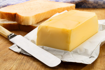 irish butter with fresh sliced bread on a wooden board