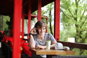 Lifestyle portrait of a young man using a smart phone outdoors