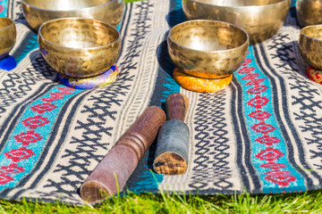 Singing bowls for massage in a row on grass