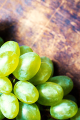 Fresh green grapes macro. Grapes on a vintage wooden table.