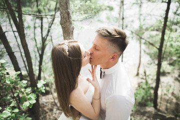 Fototapeta premium Kissing wedding couple staying over beautiful landscape