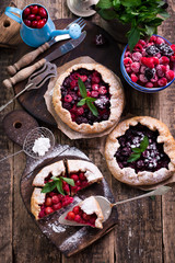 Blueberry,cherry,raspberry and blackcurrant galette on w wooden background.