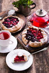 Blueberry,cherry,raspberry and blackcurrant galette on w wooden background.