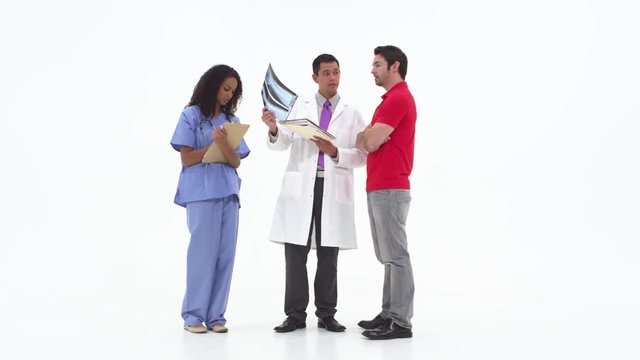 Doctor showing x-rays with patient with nurse taking notes