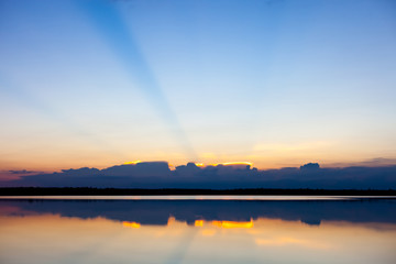 Fototapeta na wymiar Sunset landscape with blue sky over the calm lake.
