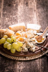 Composition of cheese, berries, bottles and glasses of wine on a wooden table