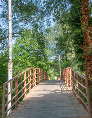 old wooden bridge over the river with a handrail