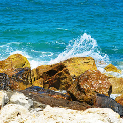 Sea waves break about stones