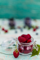 Tasty and fresh forest raspberries in jar on wooden table. 