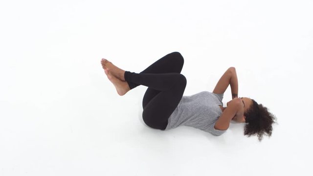Young African American woman doing crunches and exercising
