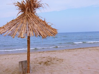 Fototapeta na wymiar Exotic beach straw umbrella on a beautiful tropical beach (Bulgaria, Sunny Beach)