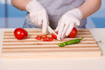 Hands of cook preparing salad