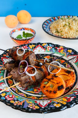 Balti lamb cooked with yoghurt and spices, caramom dried apricots, served boiled bulgur
