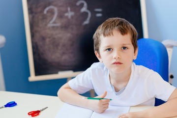 Little 7 years old boy solves multiplication table