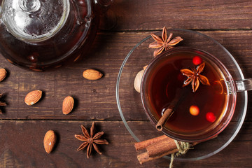 Autumn hot tea with spices and berries in glass cup