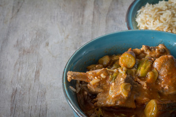 Bowl of Bamiya with Meat and Rice on Rustic Wooden Table with Copy Space