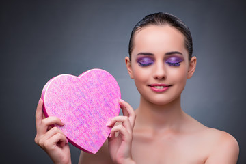 Woman with present in heart shaped box