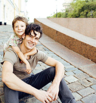 little son with father in city hagging and smiling, casual look outside playing, happy real family, lifestyle people concept