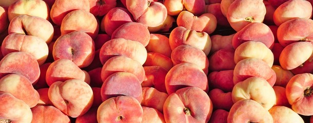 Fresh donut flat peaches at a French farmers market