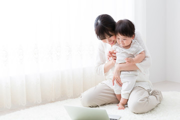 Fototapeta premium asian baby and mother using laptop in the room