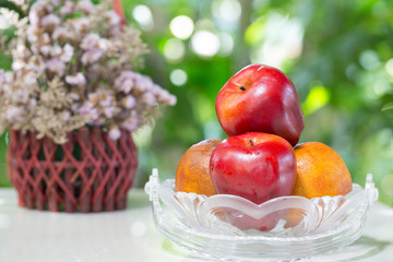 Fruits in the glass basket and basket flower on tile plate