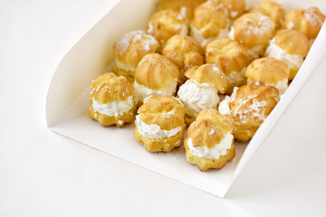 Cream puff cakes with whipped cream in white box