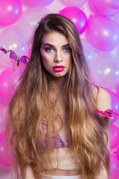 Gorgeous young woman with lush long hair with creative pink makeup