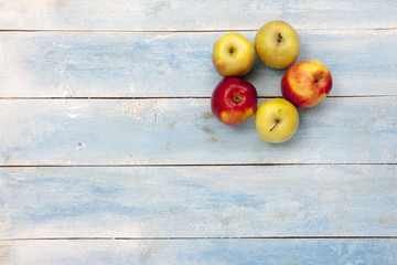 Fresh apples on blue wooden table, top view