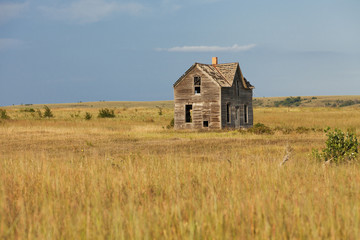 Deserted house surrounded by dry grass 