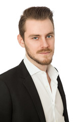 Relaxed businessman in a black blazer with a white shirt, looking at camera standing in front of a white background.