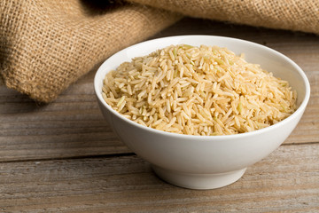Natural brown uncooked rice in white bowl