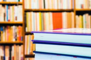 Piles of books and magazines on background of book shelf