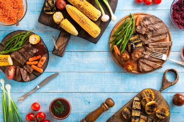 Crédence de cuisine en verre imprimé Grill / Barbecue Grilled beef steak with grilled vegetables on wooden blue table