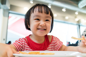 Asian Chinese little girl eating french fries