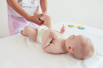 Woman doing exercises and massage the baby